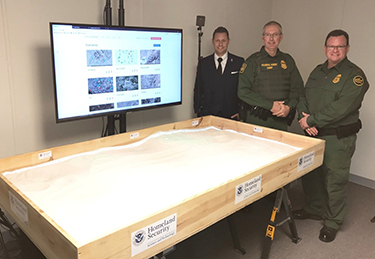 Figure 5 DHS S&T Senior Scientific and Technical Advisor Darren P. Wilson, U.S. Border Patrol Academy Chief Dan Harris, and U.S. Border Patrol Deputy Chief Scott Luck next to the transitioned Sandtable. 