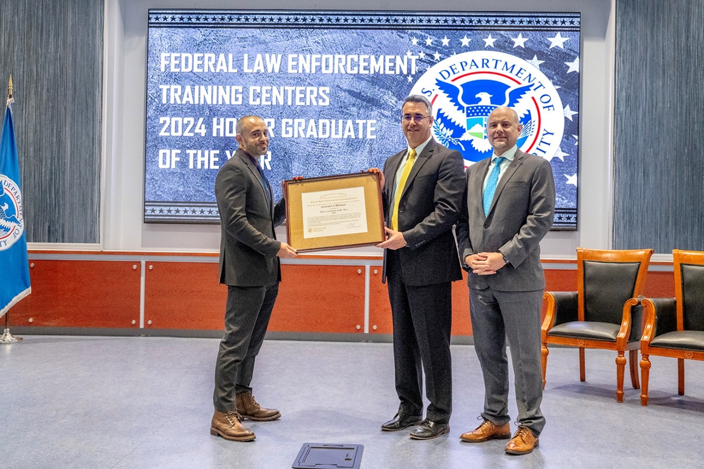Acting FLETC Director Paul E. Baker, HSI’s Acting Executive Associate Director Robert J. Hammer, and Special Agent Christopher Whitehurst during the Honor Graduate of the Year Ceremony, in Glynco, Ga., May 29, 2025. (FLETC OPA/David Tucker)