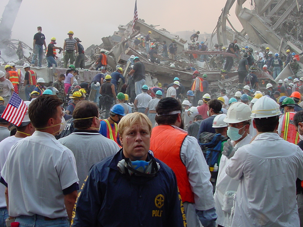 In foreground wearing blue jacket and mask, FLETC Instructor Joel Kirch, takes a moment to look away from the destruction of September 11, 2001 in New York City. (Courtesy Photo)