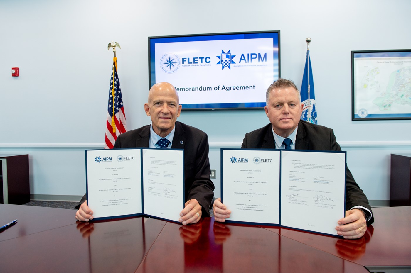 On September 23, 2022, Thomas J. Walters, Director of the Federal Law Enforcement Training Centers (FLETC), and Stuart Bartels, Executive Director of Australian Institute of Police Management (AIPM), shake hands after signing a Memorandum of Agreement to collaborate as training partners in professional exchanges. (Photo by David Tucker/FLETC)