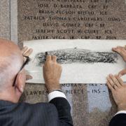 Ceremony attendees remember the fallen by tracing names engraved on the FLETC Graduates Memorial for family members.  Photo by Keith Gartman